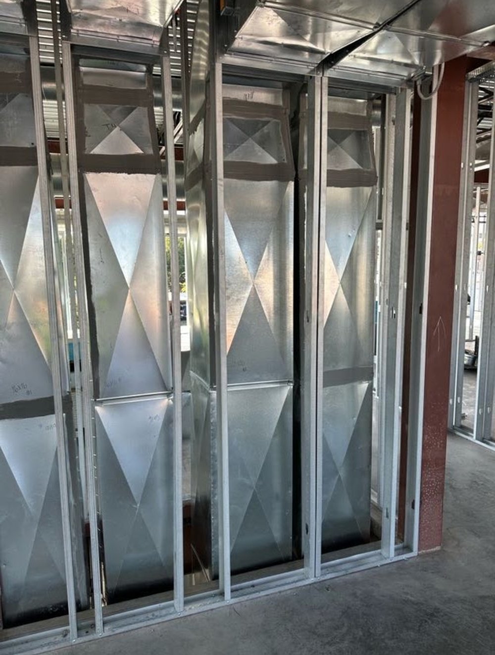 Galvanized vertical duct chases installed between metal studs